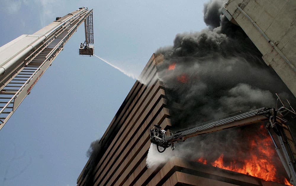 Fire fighters try to control fire in the Orchid Vipul multi storey Building in Surat.