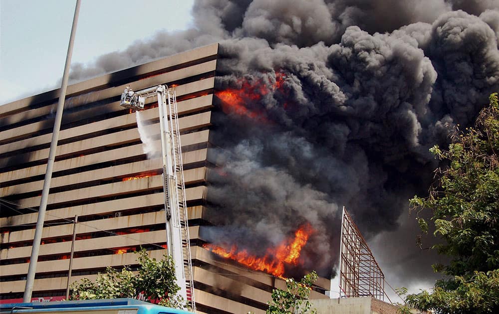 Fire fighters try to control fire that broke out in a multi-storey building in Surat.