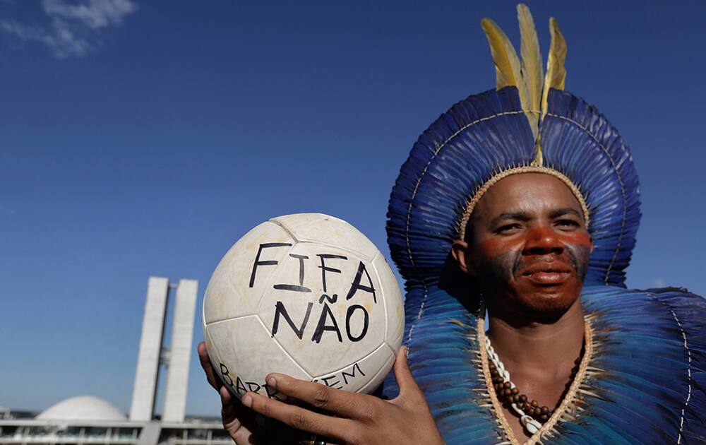 Indian Roberio Francisco from the Capinana tribe shows a soccer ball covered with the Portuguese words `No FIFA` outside Brazil`s National Congress where indigenous communities are demanding the demarcation of their lands and protesting the World Cup in Brasilia, Brazil.