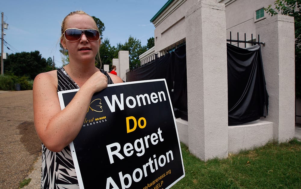 Abortion opponent Ashley Sigrest of Brandon, Miss., talks about her reasons she protests Jackson Women`s Health Organization`s clinic in Jackson, Miss. Sigrest said she regrets the abortion she had in August 1998 and supports admitting privileges laws because she believes they protect women’s health.