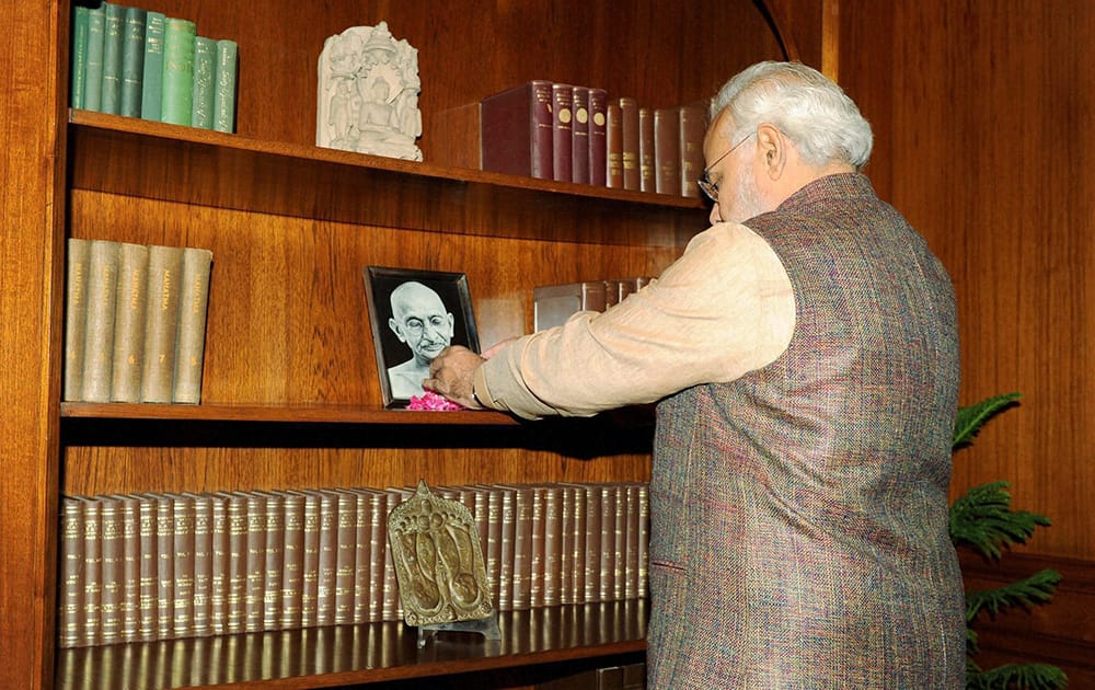 Prime Minister Narendra Modi paying tribute to Mahatma Gandhi after taking charge of the office at PMO in New Delhi.