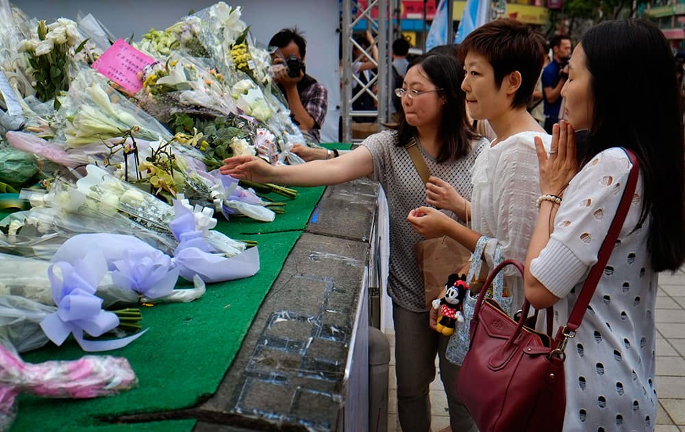 Visitors lay flowers at a makeshift memorial marking the end of the first seven days of the traditional Chinese mourning period for those killed in the last week`s knife attack aboard a subway train in Taipei, Taiwan.