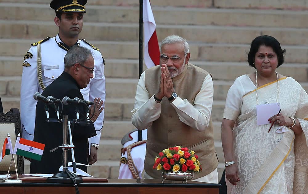 India`s new prime minister Narendra Modi, center, greets President Pranab Mukherjee, left, after taking oath of office at the presidential palace in New Delhi.