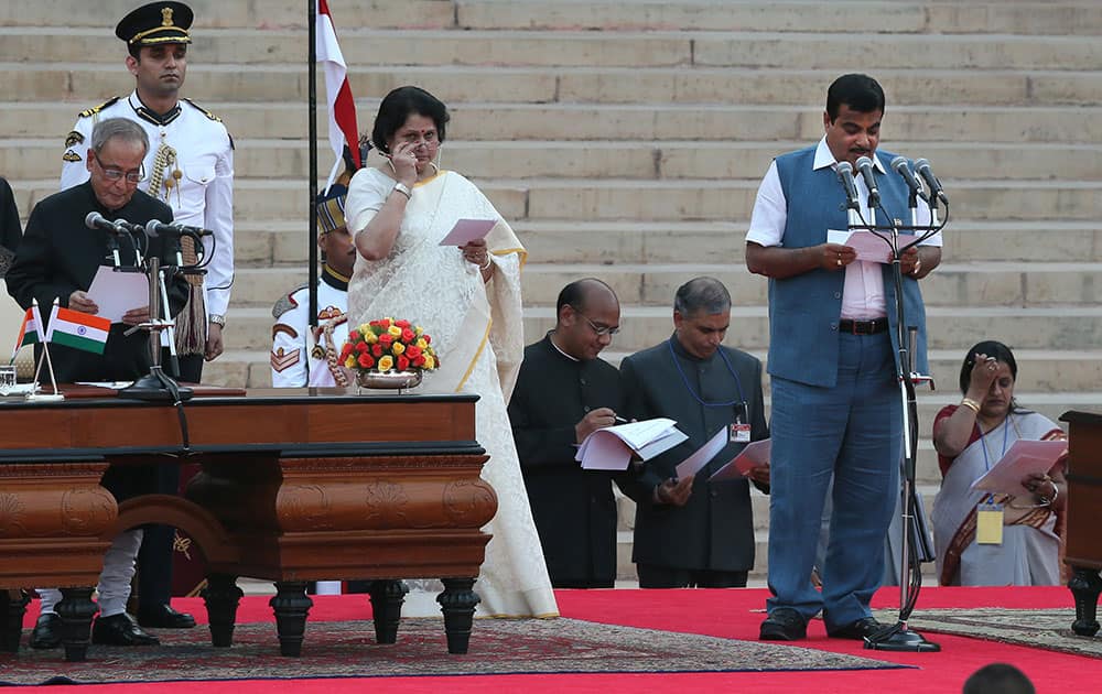 President Pranab Mukherjee, left, administers the oath of office to Cabinet Minister Nitin Gadkari, right, at the presidential palace in New Delhi