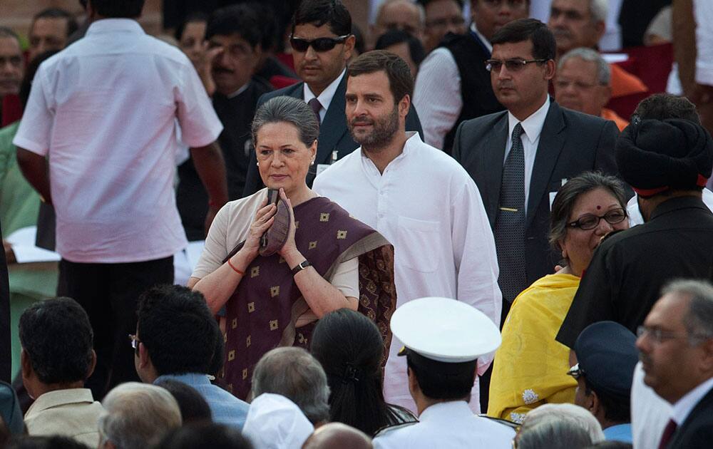 Sonia Gandhi, center, accompanied by son Rahul Gandhi, in white, arrives for the swearing in ceremony of new prime minister Narendra Modi, in New Delhi.
