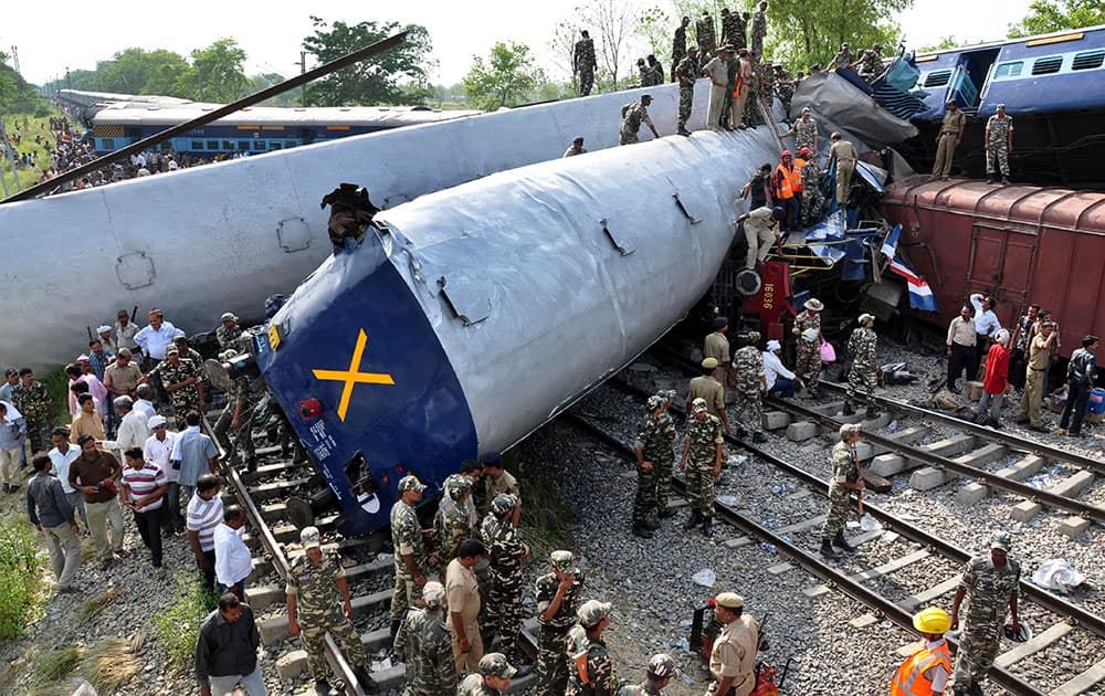 Indian officials and rescuers stand near the wreckage after the Gorakhpur Express passenger train slammed into a parked freight train Chureb, near Basti, Uttar Pradesh state, India.