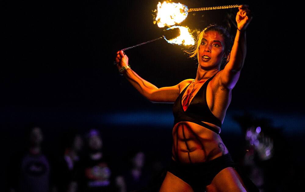 A Super Geek League firedancer shows off for attendees on the third and final day of the annual Sasquatch music festival in George, Wash.