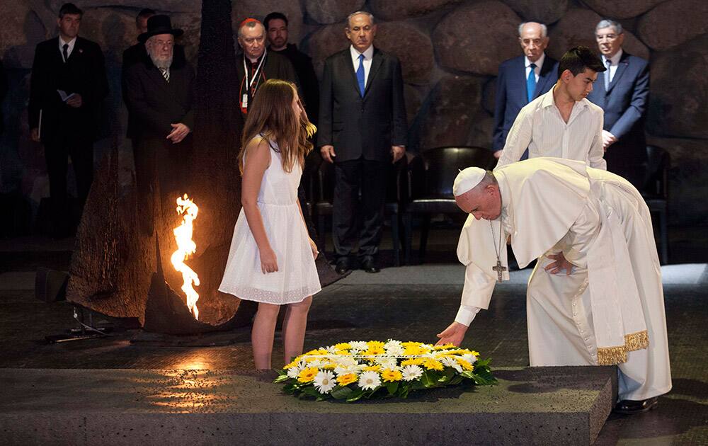 Pope Francis lays a wreath as Israel`s President Shimon Peres and Israeli Prime Minister Benjamin Netanyahu stand at the Hall of Remembrance at the Yad Vashem Holocaust memorial, in Jerusalem.