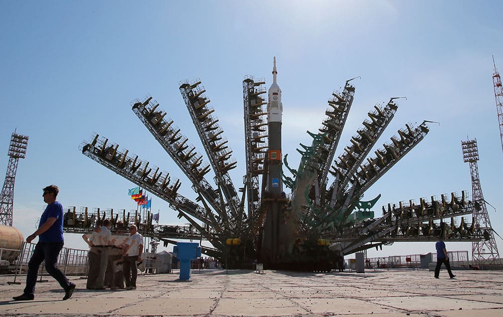 In this multiple exposure photo, service towers lift to the Russia`s Soyuz-FG booster rocket with the space capsule Soyuz TMA-13M that will carry a new crew to the International Space Station (ISS), at the launch pad at the Russian leased Baikonur Cosmodrome, Kazakhstan. The Soyuz is scheduled to launch on Thursday, May 29.