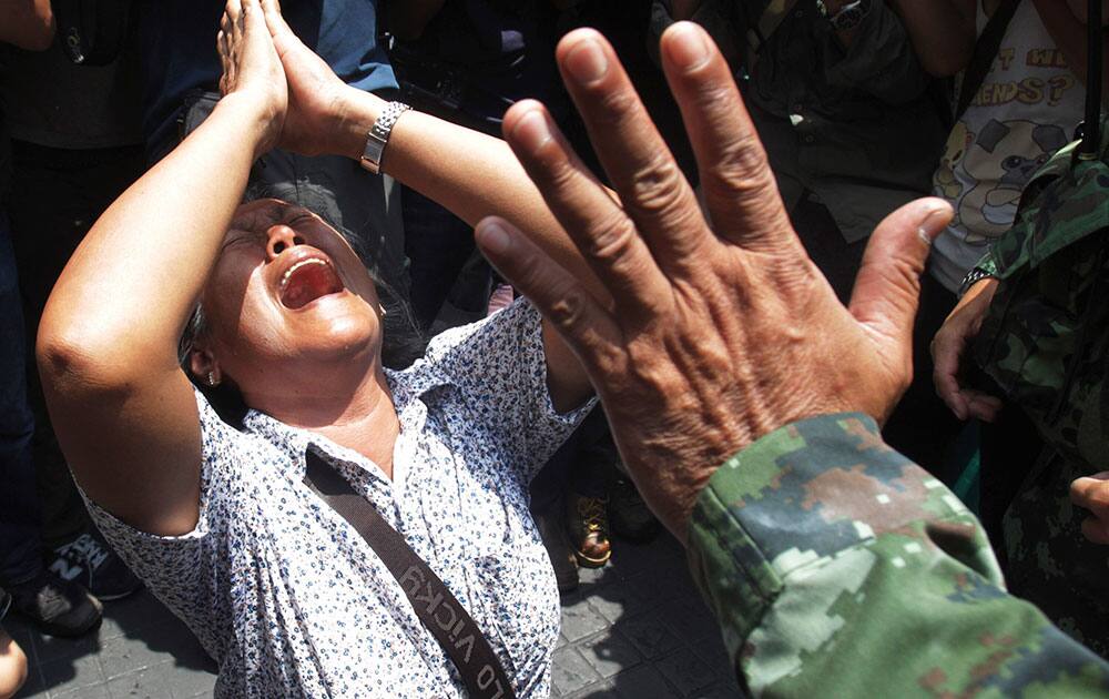 An anti-coup protester cries as she asks a Thai soldier to go away during a demonstration in Bangkok.