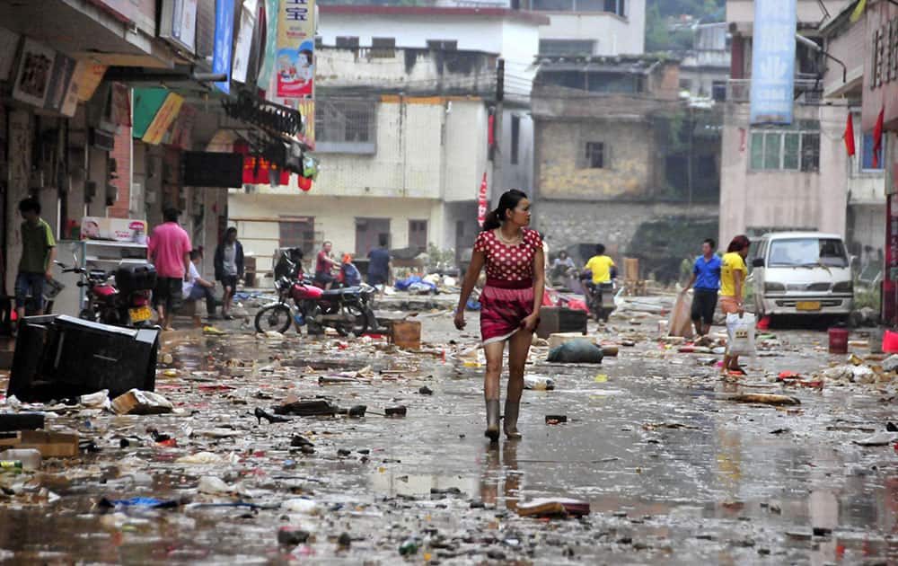 Residents walk on a street after flooding subsided in Shitan Town of Qingyuan, south China`s Guangdong Province. The Chinese state news agency is reporting 12 people have died in widespread flooding in southern China. Xinhua News Agency said the flooding affected 649,000 people in Qingyuan city in Guangdong province as of Saturday afternoon, with 3,300 houses collapsing.