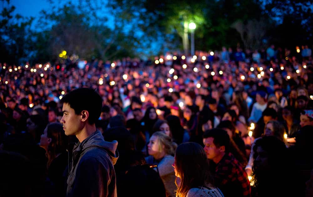 People gather at a park for a candlelight vigil to honor the victims of Friday night`s mass shooting in Isla Vista, Calif.