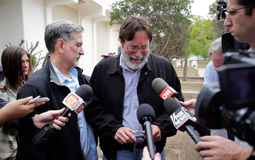 Richard Martinez, center, who says his son Christopher Martinez was killed in Friday night`s mass shooting that took place in Isla Vista, Calif., is comforted by his brother, Alan, as he talks to media outside the Santa Barbara County Sheriff`s Headquarters in Santa Barbara, Calif.
