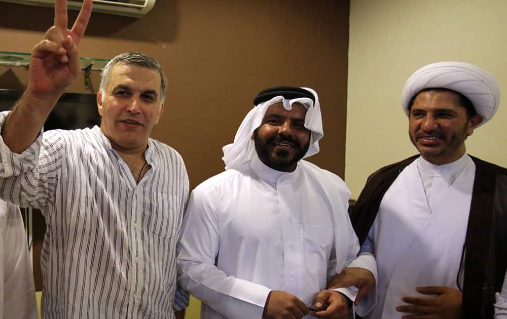 Nabeel Rajab, head of the Bahrain Center for Human Rights, left, gestures as he stands with well-wishers Osama Tamimi, center, a former Sunni independent lawmaker who often criticized the government`s handling of the uprising and recently was voted out of parliament by his peers, and Sheik Ali Salman, right, head of the largest Shiite opposition group Al-Wefaq, at Rajab`s home in Bani Jamra, Bahrain.