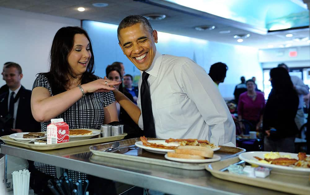 President Barack Obama shares a laugh with a patron as they get breakfast at Valois Cafeteria in Chicago.