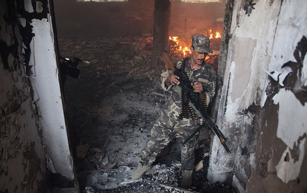 An Afghan soldier takes position at the site of a clash between insurgents and security forces at the Indian Consulate in Herat, Afghanistan.