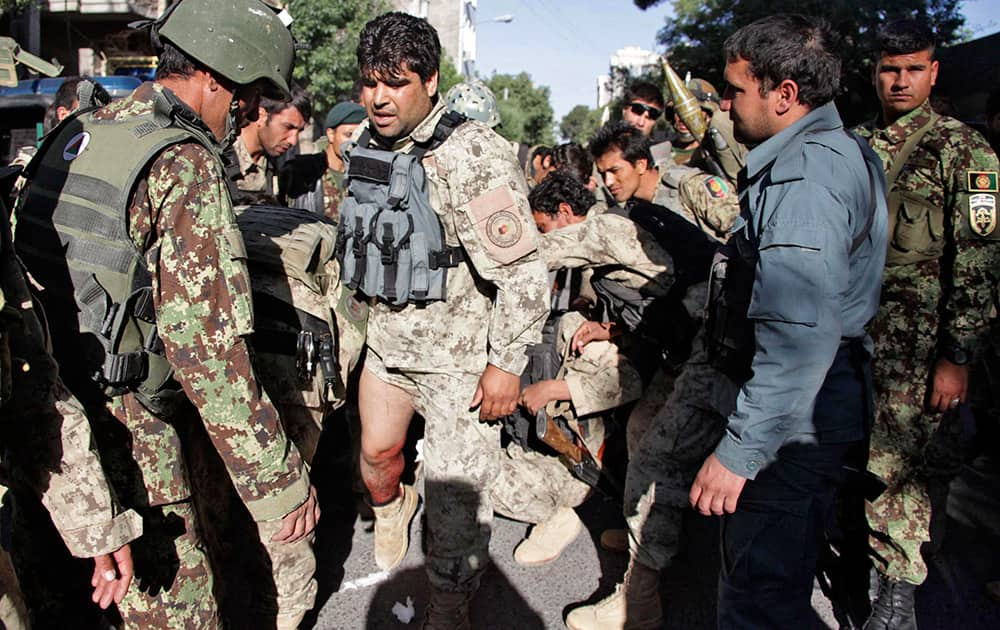 A wounded Afghanistan`s National Army (ANA) soldier receives treatment from his colleagues at the site of a clash between insurgents and security forces over Indian Consulate in Herat, Afghanistan.