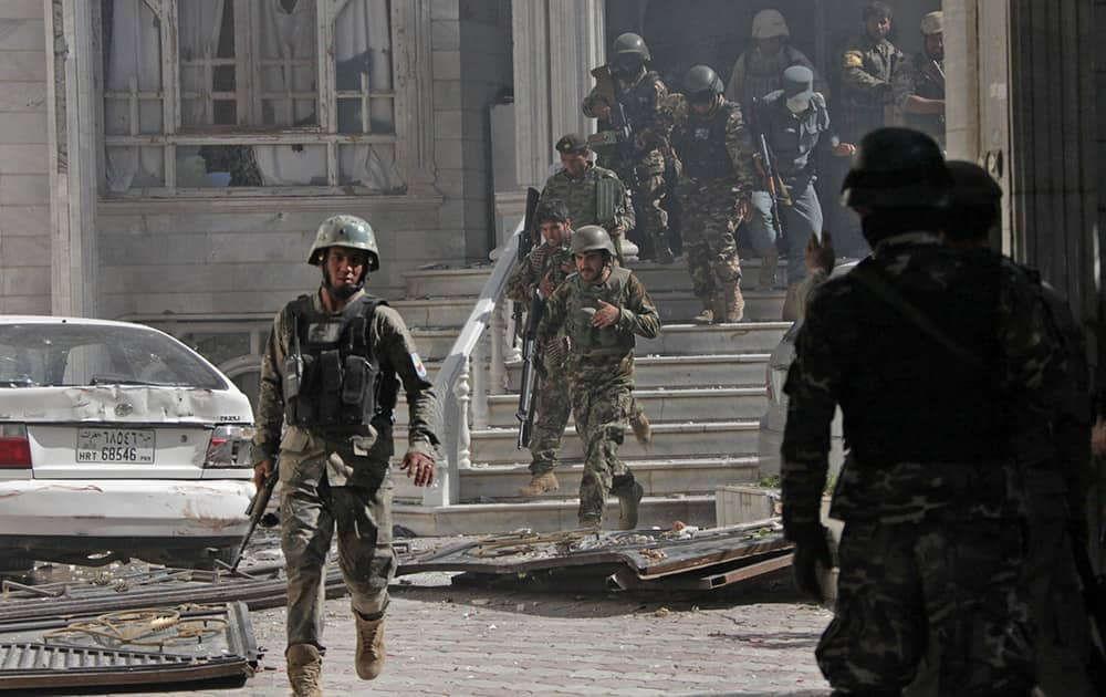 Afghanistan`s National Army (ANA) soldiers walk at the site of a clash between insurgents and security forces at the Indian Consulate in Herat, Afghanistan.