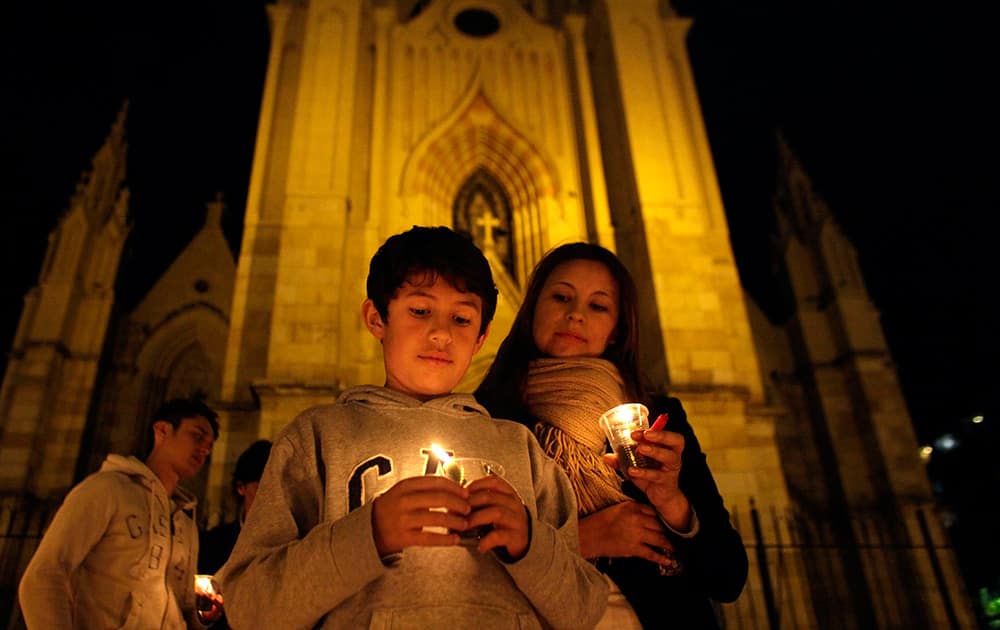 A boy holds a candle during a vigil for peace called by the Social Party of National Unity, that supports the re-election of President Juan Manuel Santos, in Bogota, Colombia.