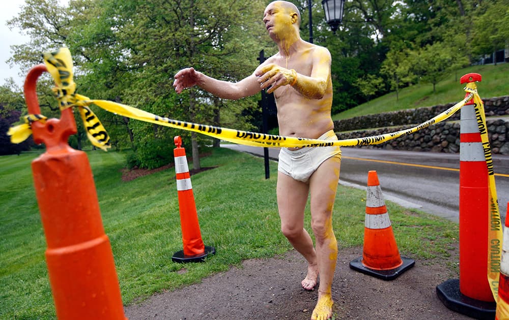 A fiberglass sculpture at Wellesley College, entitled `Sleepwalker,` is surrounded by cones and yellow caution tape after being defaced Tuesday night with yellow paint on its face, left arm, left leg, and a foot. 