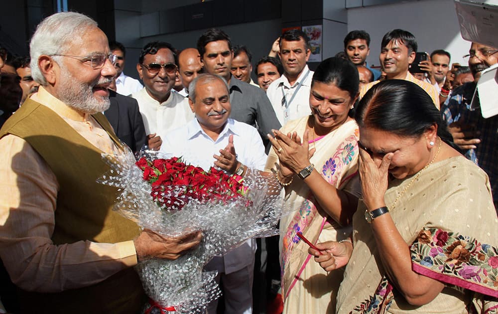 Narendra Modi speaks to new chief minister of Gujarat state Anandiben Patel during a ceremony in Gandhinagar.