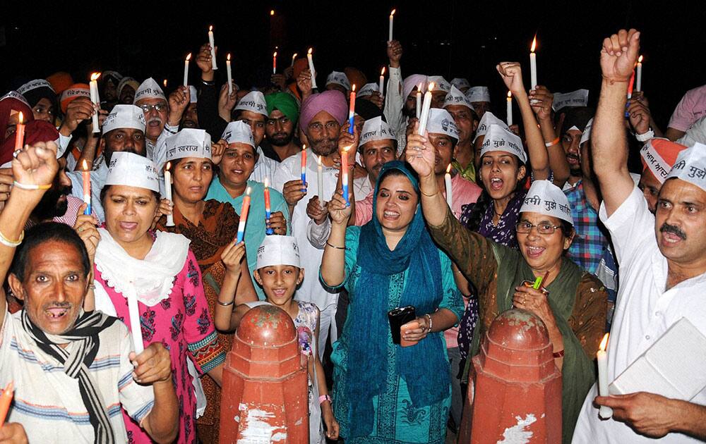 AAP activists during a candle light vigil in Amritsar on Wednesday against jail to party president Arvind Kejriwal.