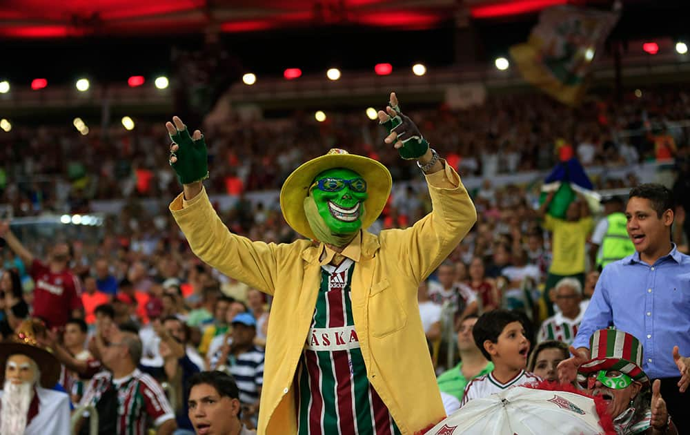 A Fluminense fan wearnig a mask and sunglasses with the brazilian national flag cheers for his team during the last Brazilian league soccer match in Maracana stadium between Fluminense and Sao Paulo, in Rio de Janeiro, Brazil.