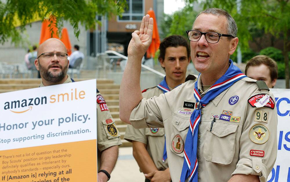 Geoffrey McGrath, a gay Boy Scout troop leader and Eagle Scout from Seattle, who had his membership in the Scouts revoked by the organization earlier this year, holds up the three fingers of the Scout Sign and recites the `Scout Law,` as he stands in front of a group of Boy Scouts and scout leaders, outside the headquarters of Amazon.com in Seattle. 