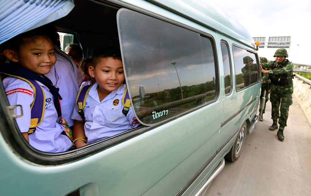 Thai soldiers push a school van while guarding an area near a pro-government demonstration site on the outskirts of Bangkok, Thailand.