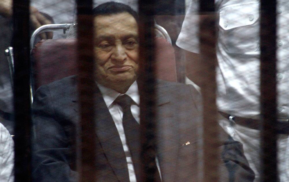 Ousted Egyptian President Hosni Mubarak, sits in the defendants cage behind protective glass, during a court hearing in Cairo, Egypt.