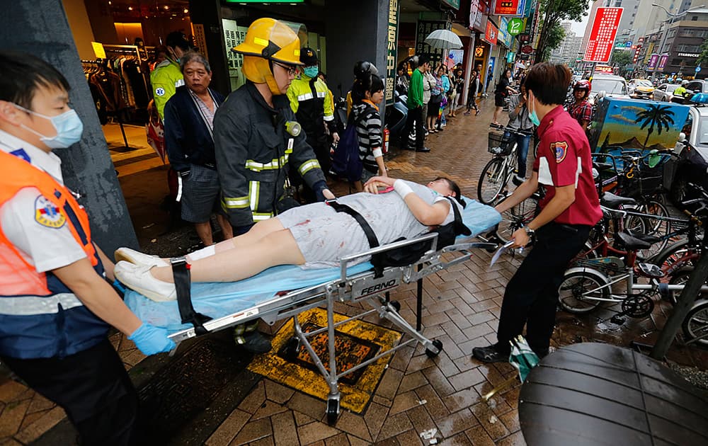 Paramedics remove a victim from a subway station exit after a knife attack on a subway in Taipei, Taiwan.