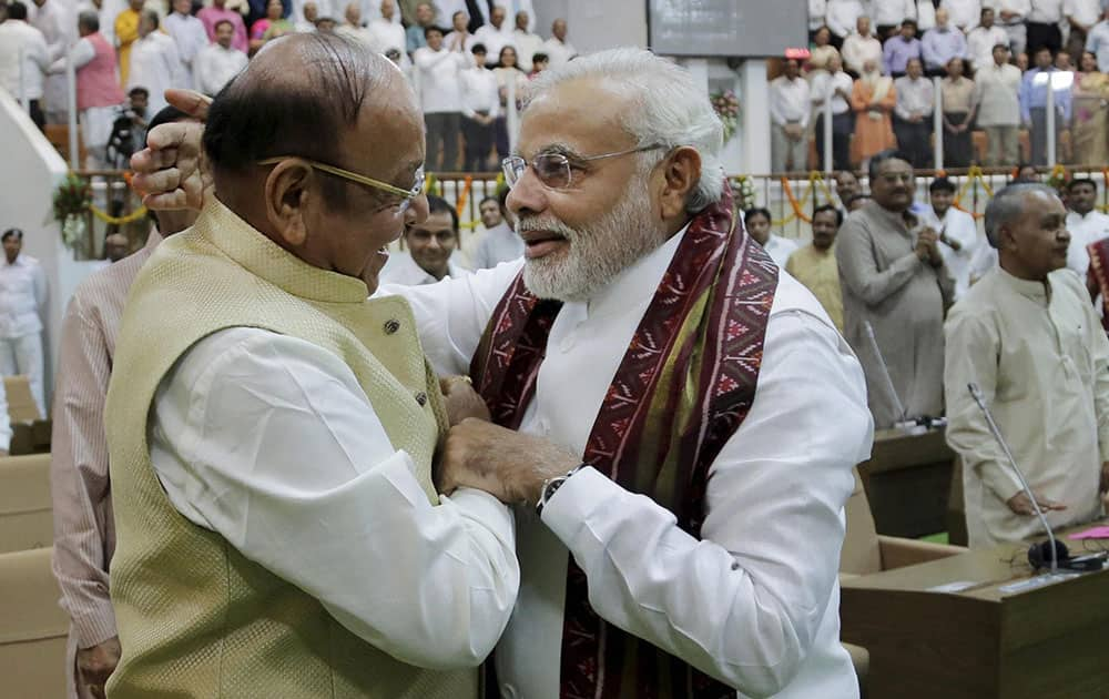 Narendra Modi is presented a shawl by senior Congress leader Shankersinh Vaghela during the special session of the state Assembly in Gandhinagar.