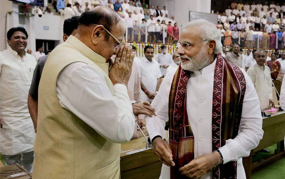 Prime Minister-elect and Gujarat Chief Minister Narendra Modi is greeted by senior Congress leader Shankersinh Vaghela during the special session of the state Assembly in Gandhinagar.