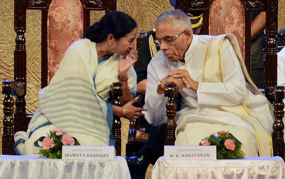 West Bengal Governor M K Narayanan talks to Chief Minister Mamata Banerjee during celebrations on the third anniversary of the TMC government at Science City in Kolkata.