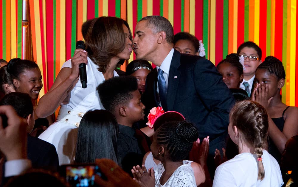 President Barack Obama and first lady Michelle Obama kiss on stage during the White House Talent Show in the East Room of the White House.