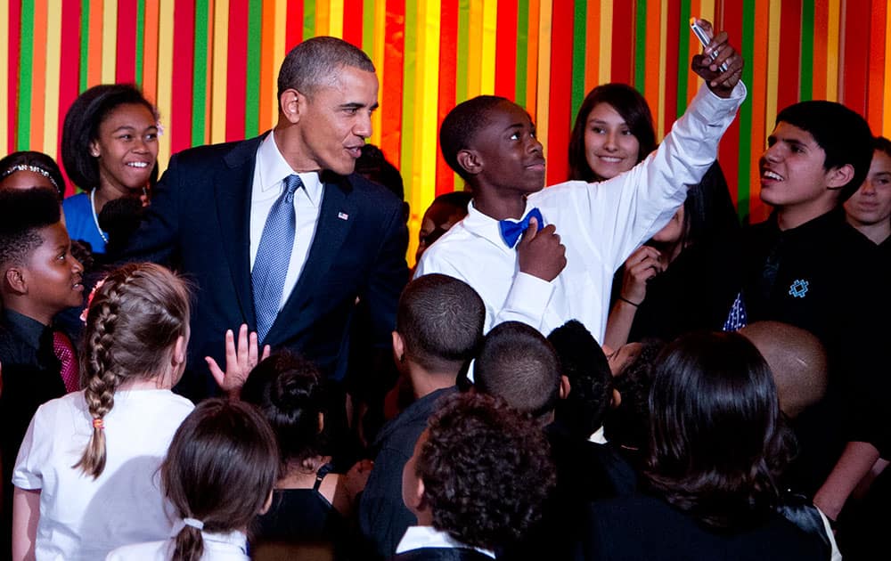 President Barack Obama takes a `selfie` on stage with a a student from the ReNew Cultural Arts Academy, from New Orleans, during the White House Talent Show in the East Room of the White House.