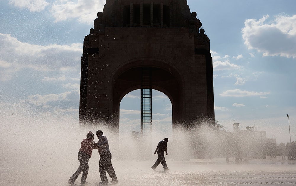 People play in an outdoor fountain on a warm afternoon in Mexico City.