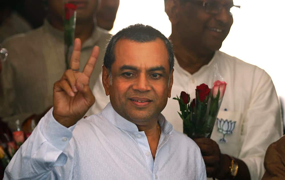 Paresh Rawal displays the victory symbol as he arrives for a meeting of the party`s newly elected lawmakers in New Delhi.