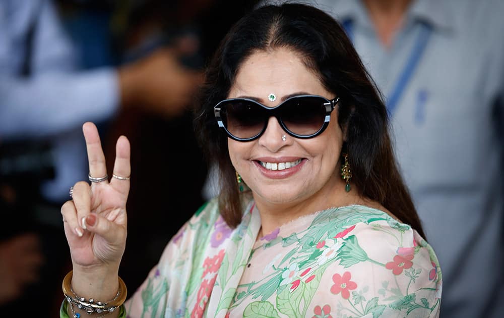 Kirron Kher displays the victory symbol as she arrives for a meeting of the party`s newly elected lawmakers in New Delhi.