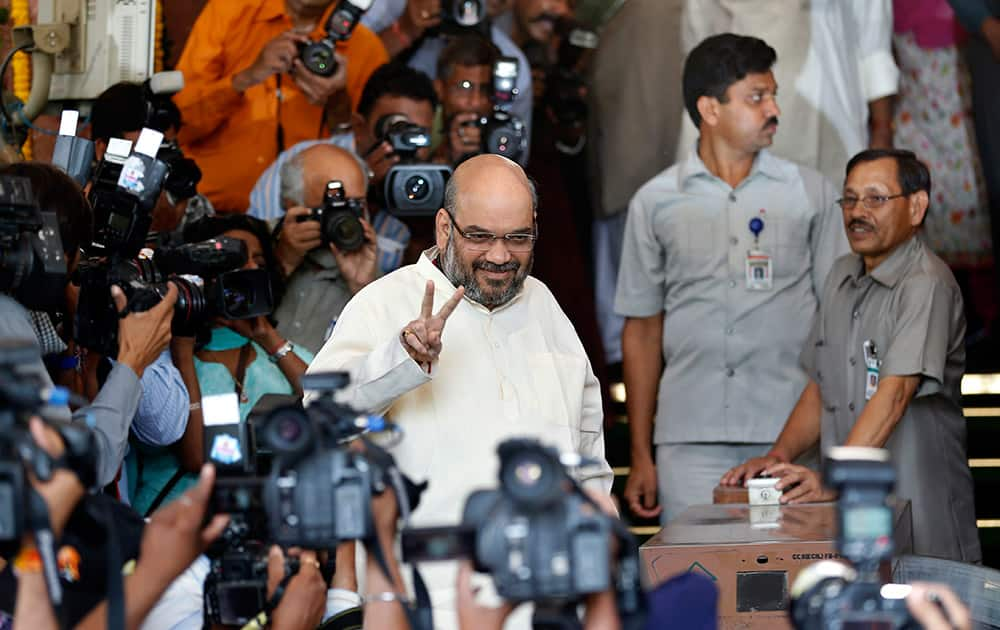 Amit Shah displays the victory symbol as he arrives for a meeting of the party`s newly elected lawmakers in New Delhi.