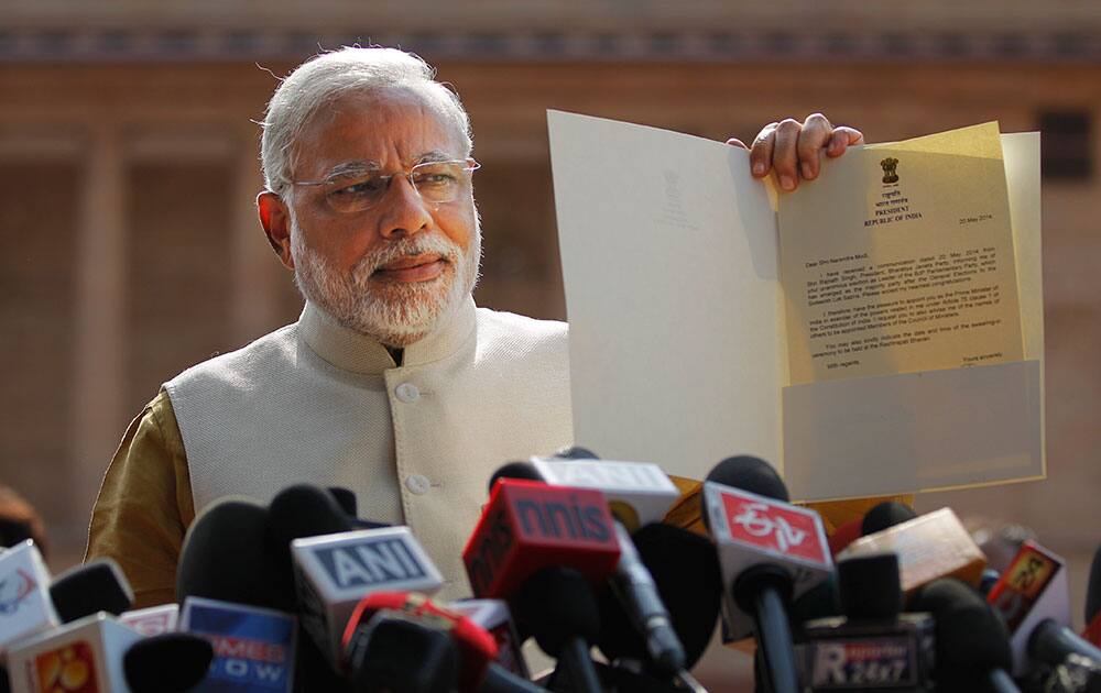 Narendra Modi displays the letter from the Indian President inviting him to form the new government, outside the Presidential Palace in New Delhi.