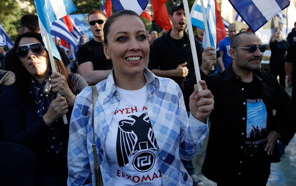 A supporter of far-right political party Golden Dawn wears a T-shirt reading ``Golden Dawn…We Are Coming`` during a rally in Athens. Struggling to form alliances, Europe’s far-right is softening its image, as a wide variety of anti-establishment parties seek gains across a continent emerging from financial crisis.