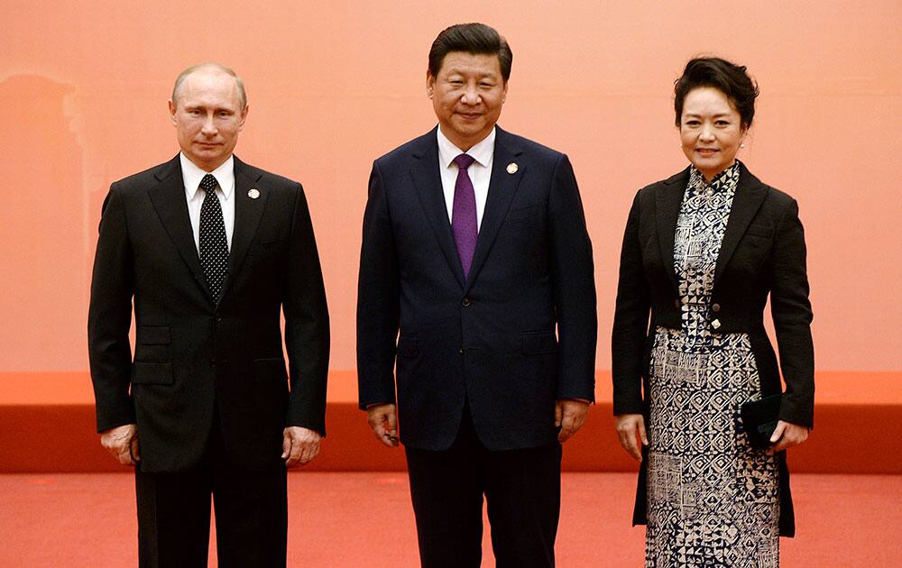 Russian President Vladimir Putin, left, Chinese President Xi Jinping, center, and his wife Peng Liyuan pose for photos at the fourth Conference on Interaction and Confidence Building Measures in Asia (CICA) summit in Shanghai, China.