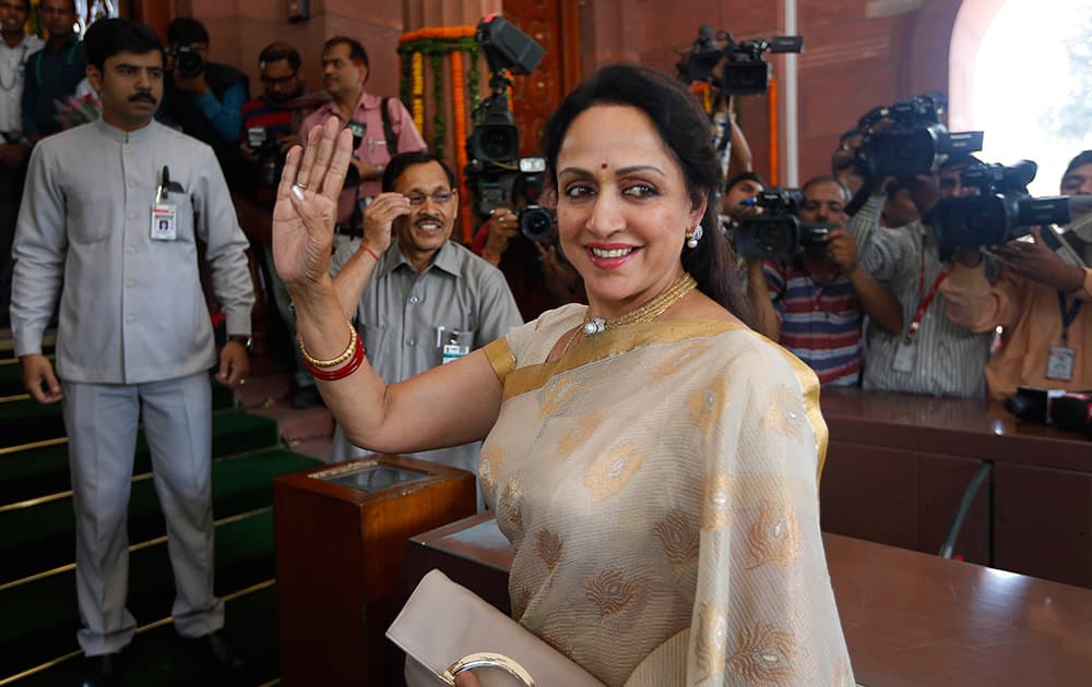 Hema Malini waves to cameras as she arrives for the BJP parliamentary party meeting in New Delhi.