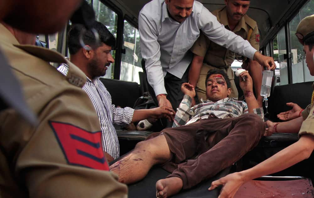 A passenger who was injured after a private bus plunged off a mountain road into a deep gorge in Kashmir is brought for treatment at the government medical college hospital in Jammu.