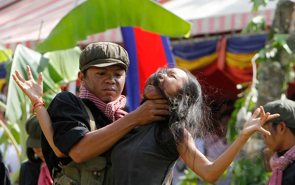 Cambodian students from the Royal University of Fine Arts re-enact torture executed by the Khmer Rouge during their reign of terror in the 1970s to mark the annual Day of Anger at Choeung Ek, a former Khmer Rouge 