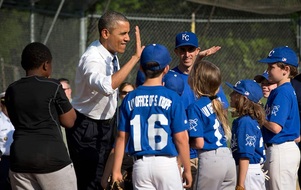 President Barack Obama greets players as he makes an unannounced stop to surprise members of the Northwest little league baseball teams at Friendship Park in Washington.