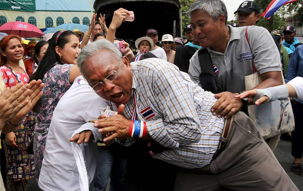 Leader of anti-government protesters Suthep Thaugsuban reacts as he is hugged by a supporter during a march in Bangkok, Thailand.