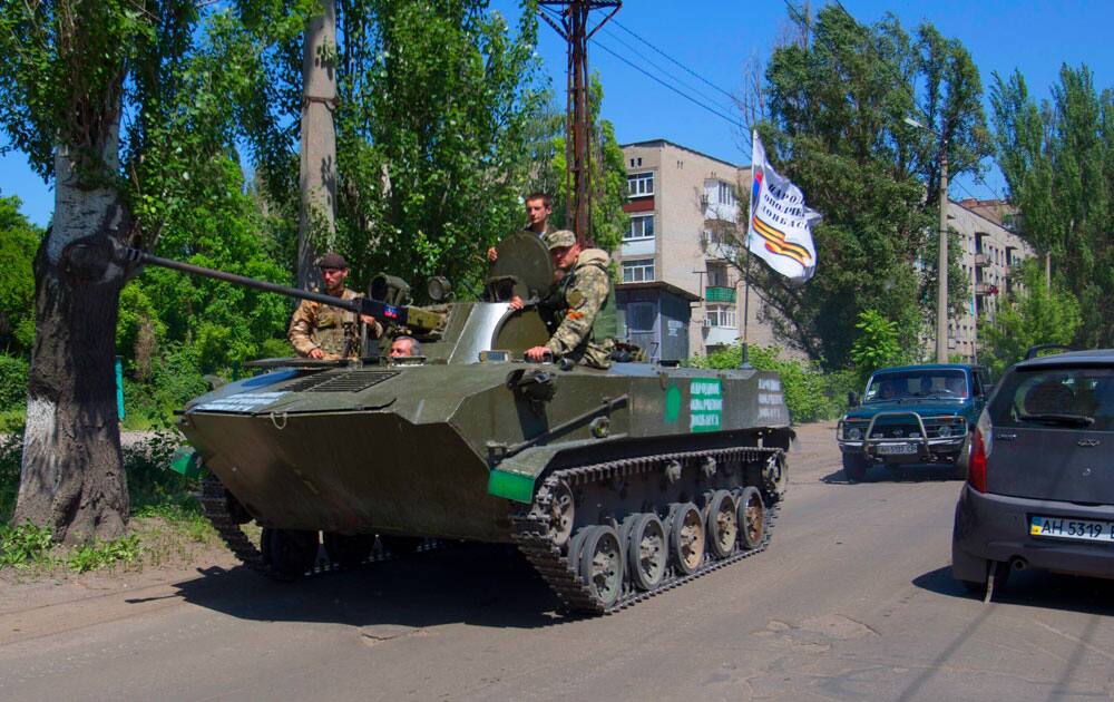 Pro-Russian militants drive atop of an armored personal carrier as they guard streets in Slovyansk, eastern Ukraine