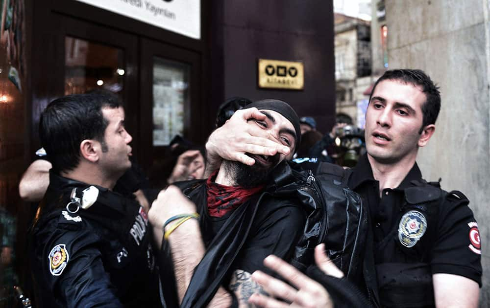 Riot police detain a protester as they use water cannons and teargas to disperse people who were protesting the Soma mine accident that killed 301 miners, in Istanbul, Turkey.